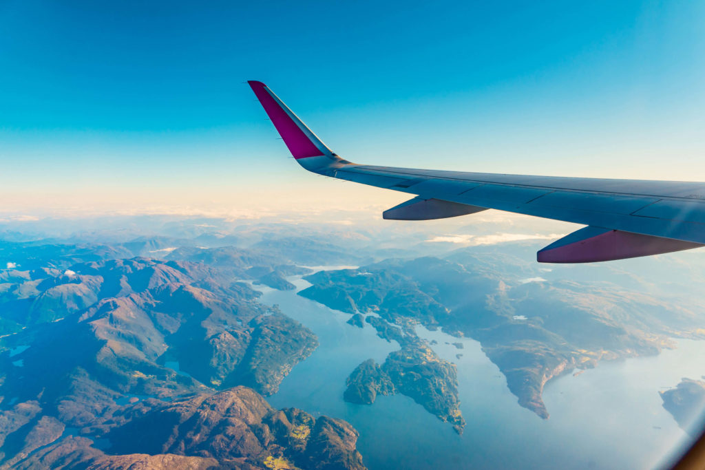 View looking out an airplane window of the fjords in Norway during a vacation with Students Fare.