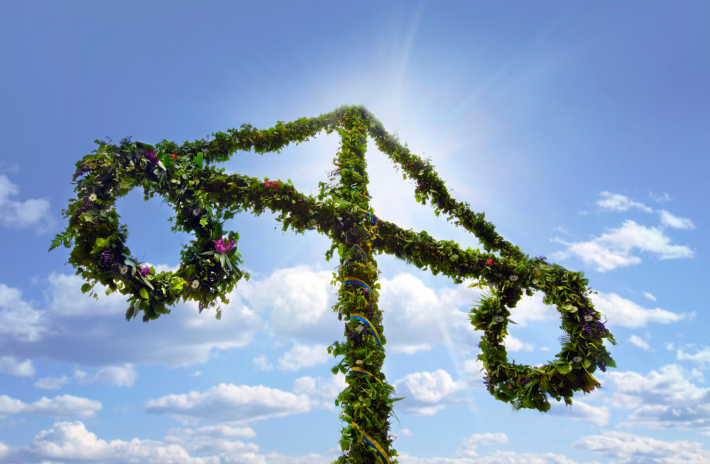 A shot of the traditional maypole wrapped in flowers, leaves, ribbons, and flowers, which the children will play with during the celebration. This image is used in the Students Fare student travel blog, "Midsummer in Sweden," which describes the traditional festival and how to celebrate it.
