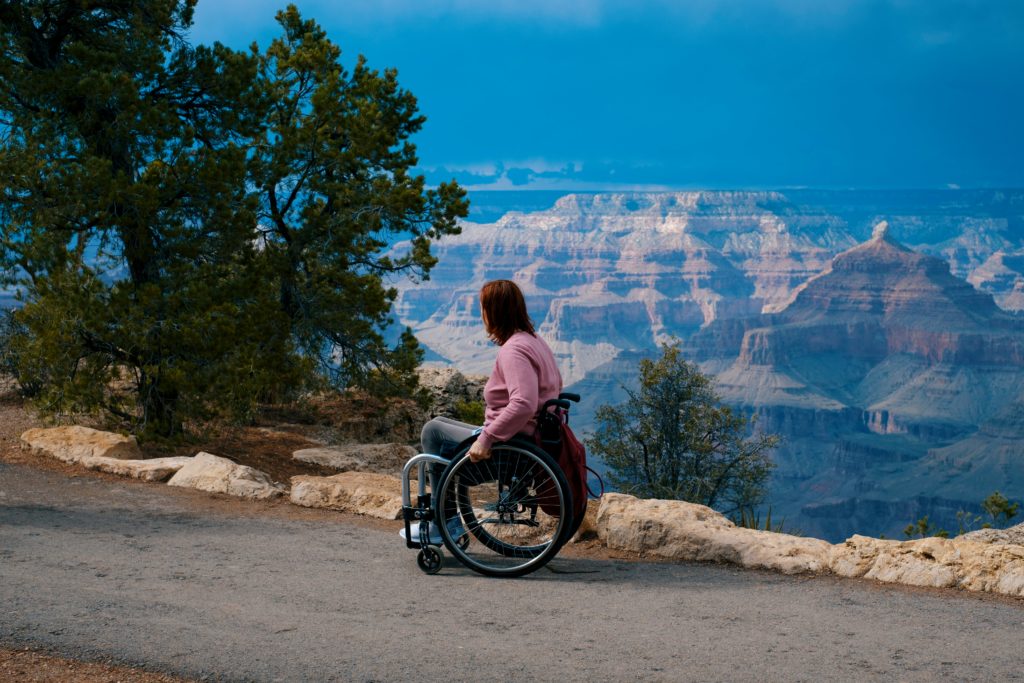 Featured in the Students Fare article, "Accessible Air Travel Guide," this image shows a female traveler using a wheelchair and viewing a gorgeous natural monument.