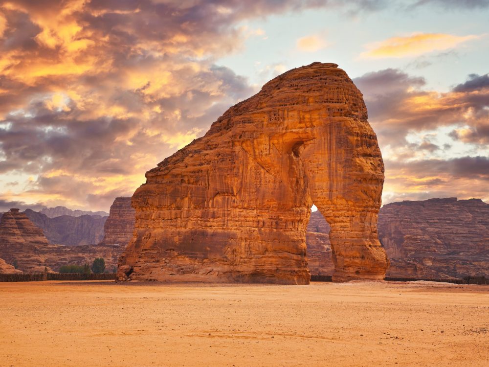 Jabal AlFil - Elephant Rock in Al Ula desert landscape dramatic sunset sky above - Saudi Arabia