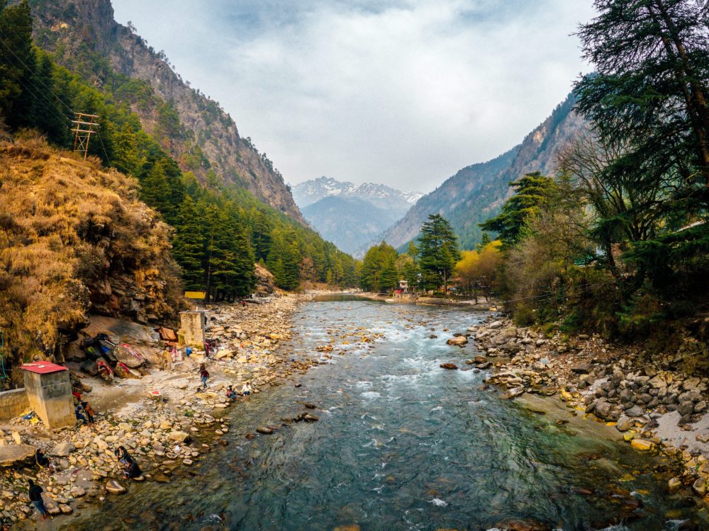 Student travelers along the banks of the Parvati River near the Khir Ganga village for the Kheerganga Trek tour in Himachal Pradesh, India.